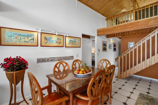 dining area featuring high vaulted ceiling and wooden ceiling