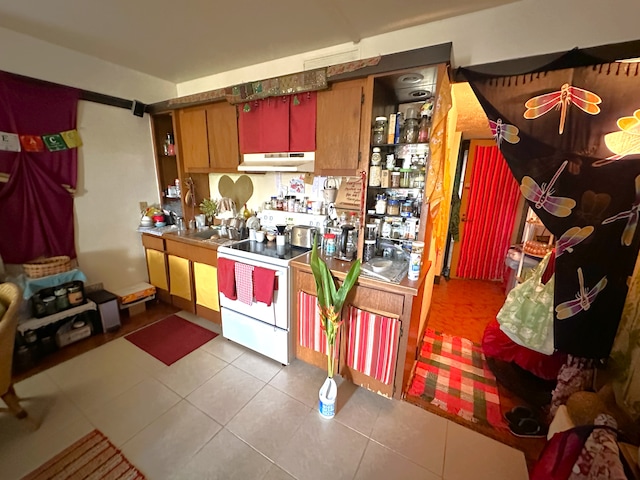 kitchen featuring white range and light tile patterned floors