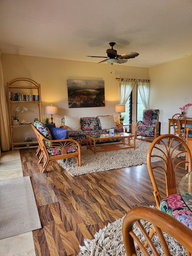 living room with ceiling fan and a textured ceiling