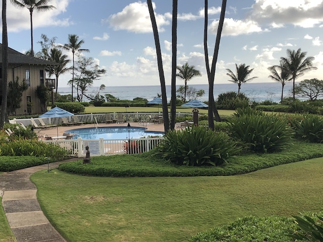 view of swimming pool with a lawn, a patio, and a water view