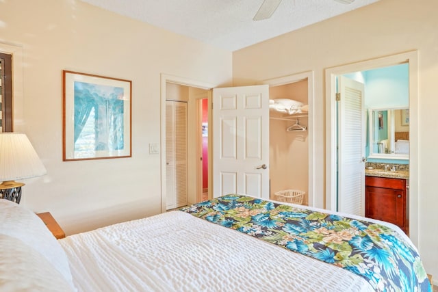 bedroom with sink, ensuite bath, a textured ceiling, and ceiling fan