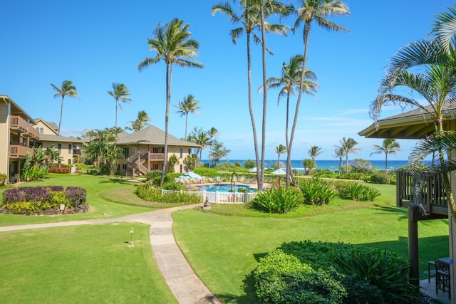 view of property's community featuring a yard and a swimming pool