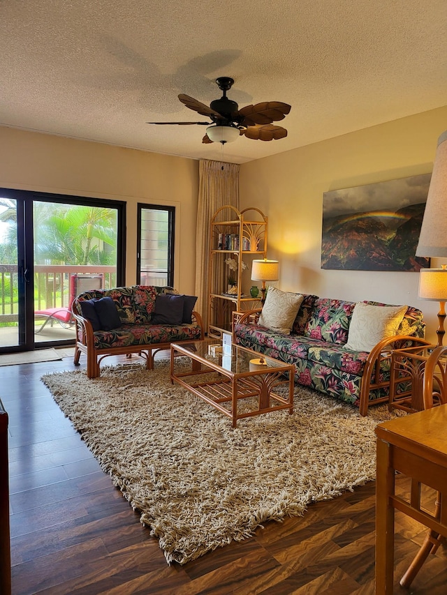 living room with ceiling fan, dark hardwood / wood-style floors, and a textured ceiling