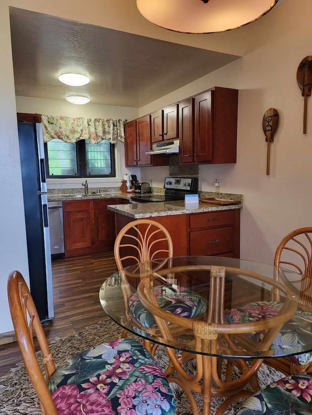 kitchen featuring sink, dark wood-type flooring, stainless steel appliances, a textured ceiling, and stone countertops