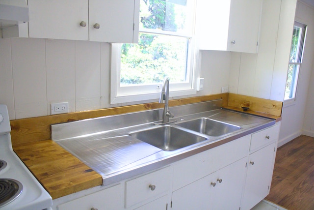 kitchen featuring range, dark hardwood / wood-style floors, a wealth of natural light, and white cabinets