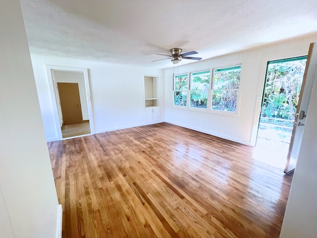 empty room with ceiling fan, hardwood / wood-style floors, and a textured ceiling