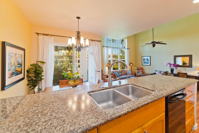 kitchen with black dishwasher, ceiling fan with notable chandelier, decorative light fixtures, and sink