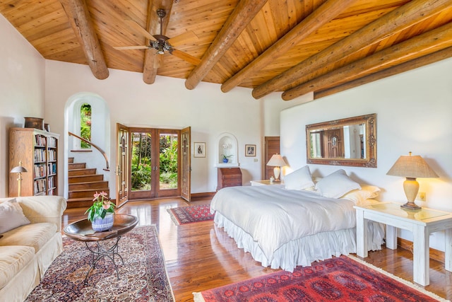 bedroom with beam ceiling, access to outside, hardwood / wood-style floors, and wood ceiling