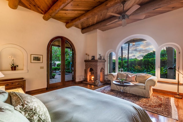 bedroom with multiple windows, a brick fireplace, hardwood / wood-style floors, and wood ceiling