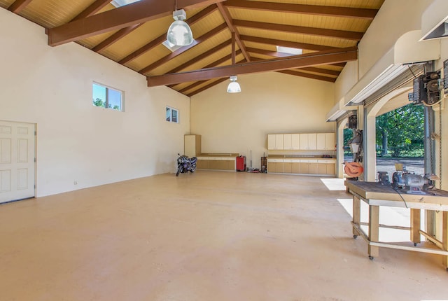 interior space featuring concrete floors, beam ceiling, high vaulted ceiling, and a healthy amount of sunlight