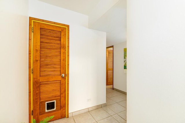 hallway with baseboards and light tile patterned flooring