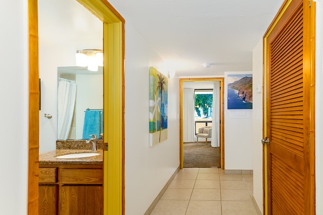 corridor featuring light tile patterned flooring and sink