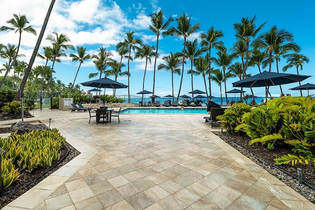 community pool with a patio and fence