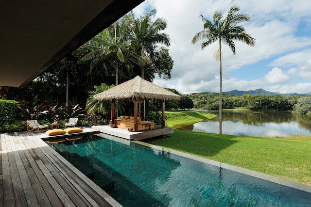 view of pool featuring a deck with water view, a gazebo, and a lawn