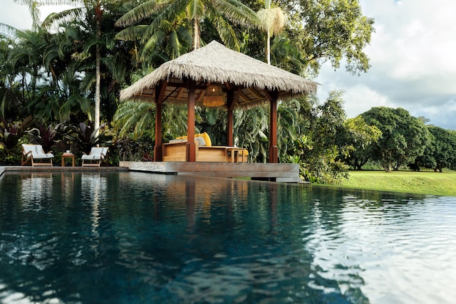 view of swimming pool with a water view and a gazebo