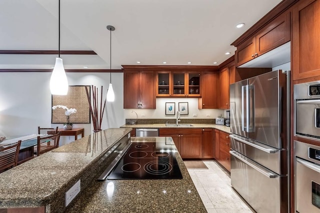 kitchen with stainless steel appliances, sink, light tile patterned floors, dark stone countertops, and hanging light fixtures