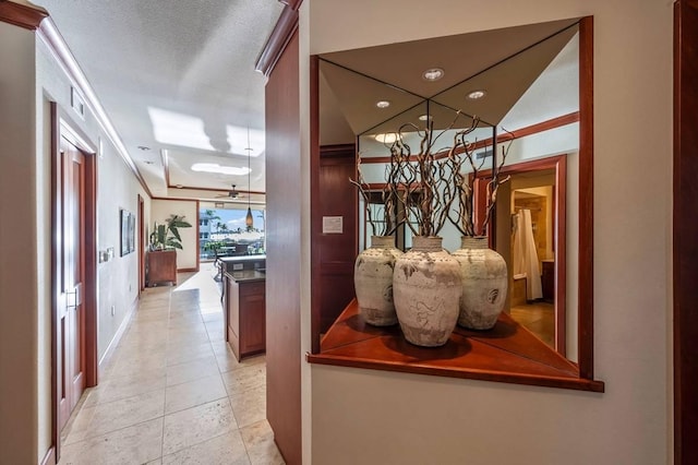 hall featuring crown molding and light tile patterned floors