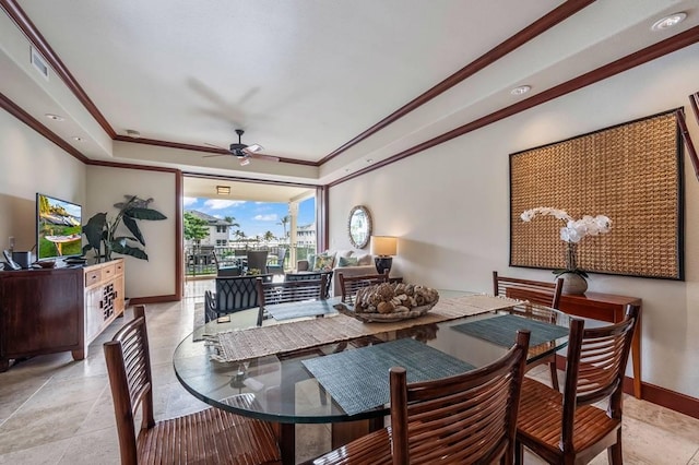 dining space with ceiling fan, ornamental molding, and a tray ceiling