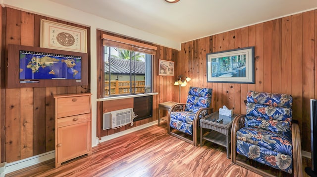 living area featuring wood walls, wood-type flooring, and a wall mounted AC