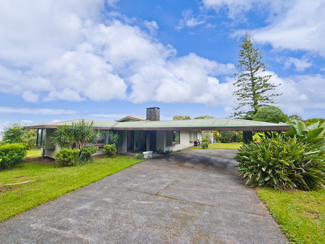 ranch-style house featuring a carport and a front lawn