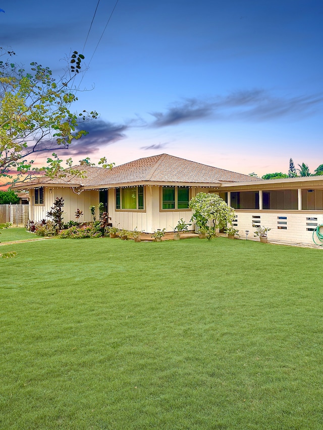 ranch-style home with a yard