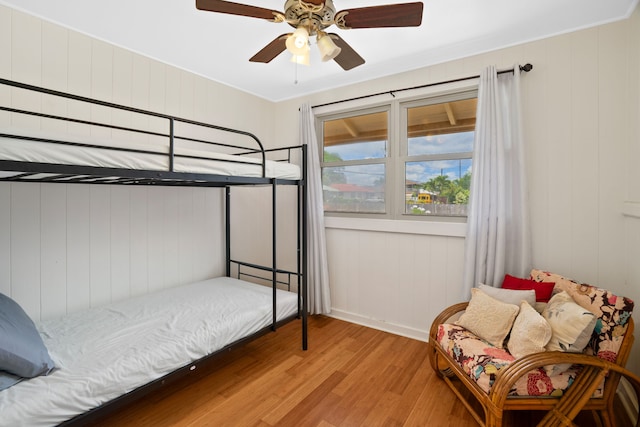 bedroom with ceiling fan, crown molding, and light hardwood / wood-style flooring