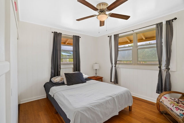 bedroom featuring wood-type flooring, ceiling fan, and crown molding