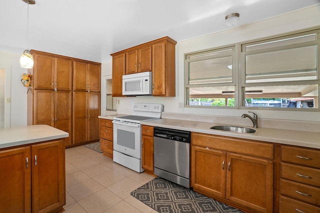 kitchen featuring sink, pendant lighting, white appliances, and light tile patterned floors