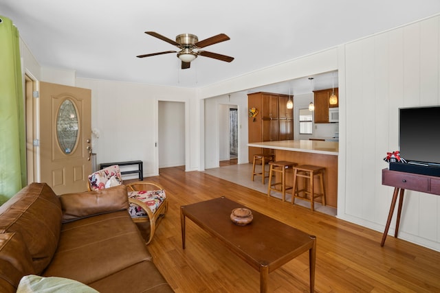 living room with light hardwood / wood-style floors and ceiling fan