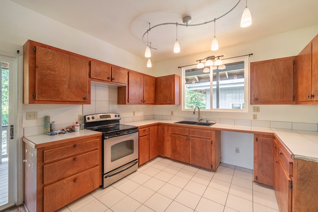 kitchen featuring electric stove, hanging light fixtures, sink, light tile patterned floors, and track lighting