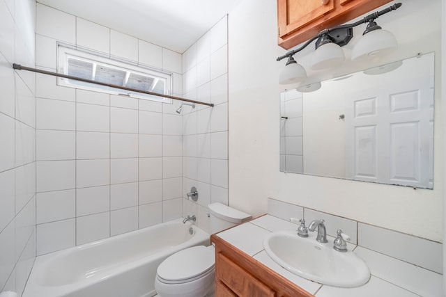 full bathroom with toilet, tiled shower / bath combo, and vanity