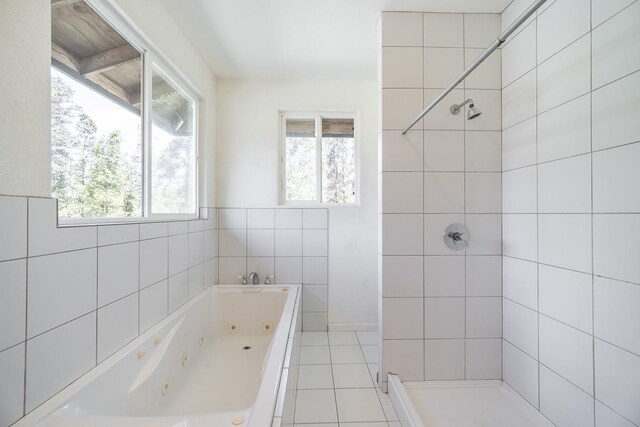 bathroom featuring tile patterned flooring, tile walls, and a wealth of natural light