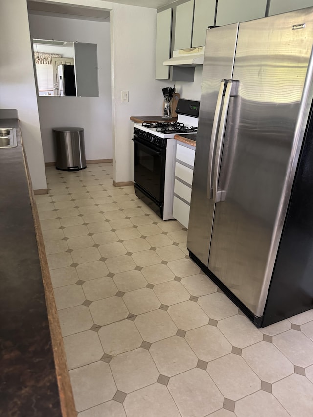 kitchen featuring white cabinetry, stainless steel fridge, range with gas stovetop, and sink