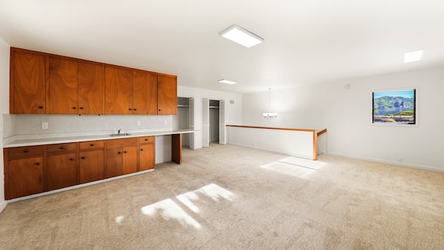 kitchen with light carpet, decorative backsplash, and sink