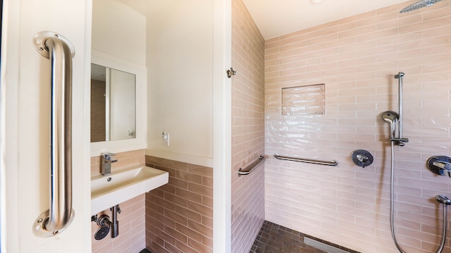 bathroom featuring tiled shower and sink