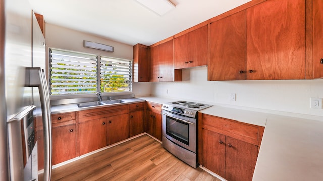 kitchen with stainless steel appliances, sink, and light wood-type flooring