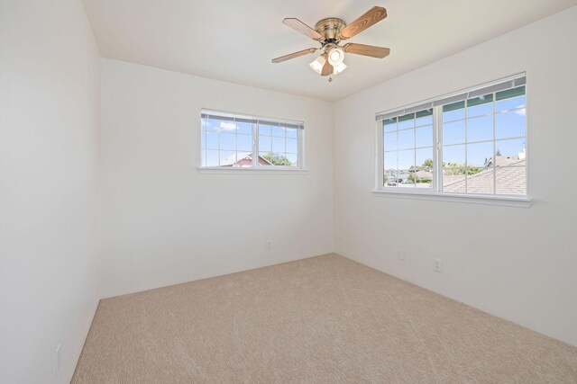 unfurnished room with carpet, a healthy amount of sunlight, and ceiling fan