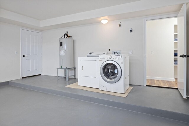 washroom with electric water heater, independent washer and dryer, and hardwood / wood-style floors