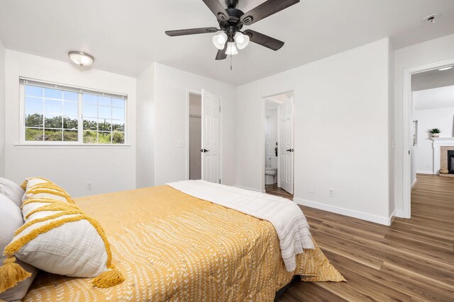 bedroom with connected bathroom, hardwood / wood-style flooring, and ceiling fan