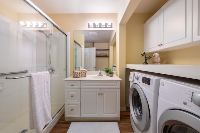 laundry area featuring dark hardwood / wood-style flooring, washer and clothes dryer, and sink