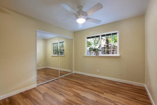 unfurnished bedroom featuring hardwood / wood-style flooring, ceiling fan, and a closet