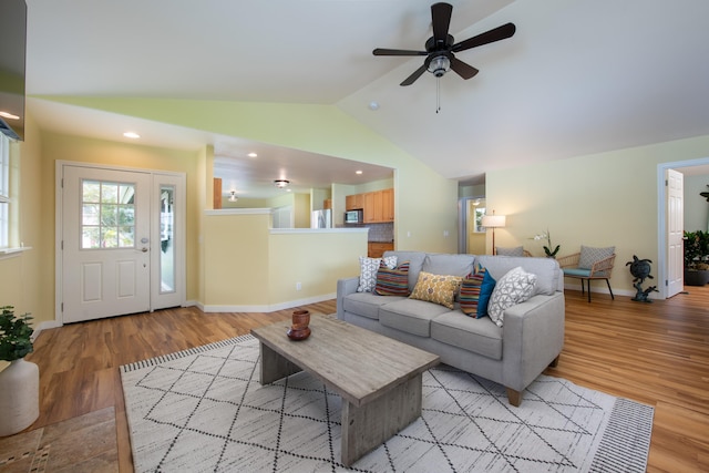 living room with lofted ceiling, light hardwood / wood-style flooring, and ceiling fan