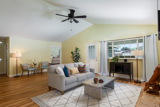 living room featuring lofted ceiling, light hardwood / wood-style flooring, and ceiling fan