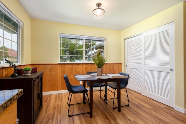 dining area featuring light hardwood / wood-style floors and wood walls