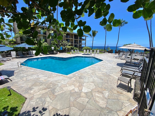 view of pool featuring a patio and a water view