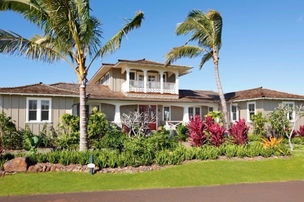 view of front facade with a balcony and a front lawn