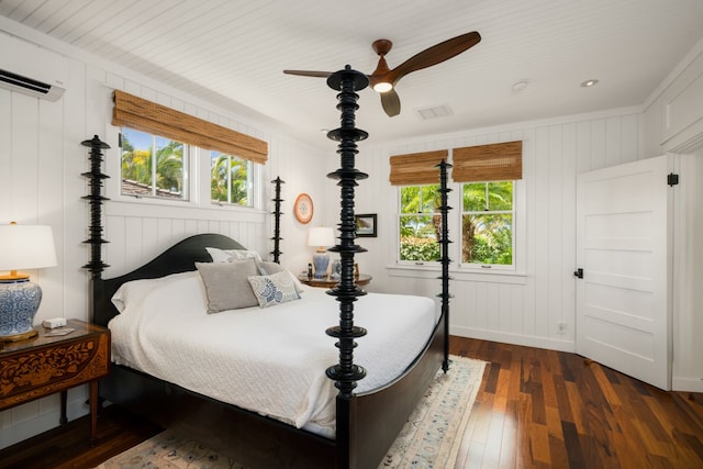 bedroom with ceiling fan, a wall unit AC, dark hardwood / wood-style floors, and multiple windows