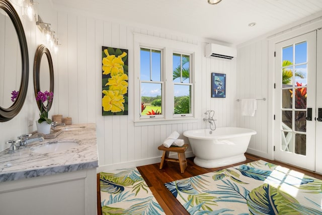 bathroom with a wall mounted air conditioner, vanity, a bathtub, and hardwood / wood-style floors