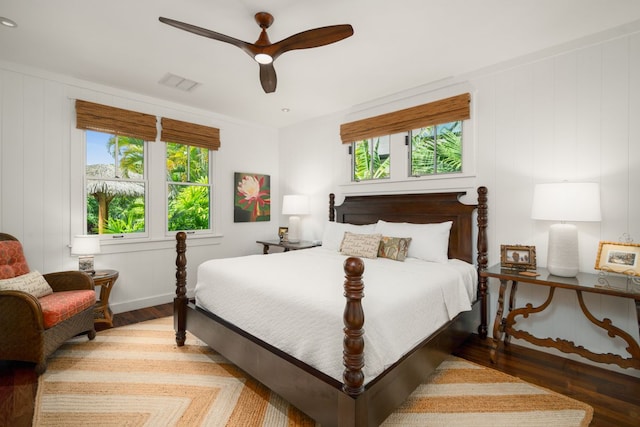 bedroom with multiple windows, hardwood / wood-style flooring, and ceiling fan