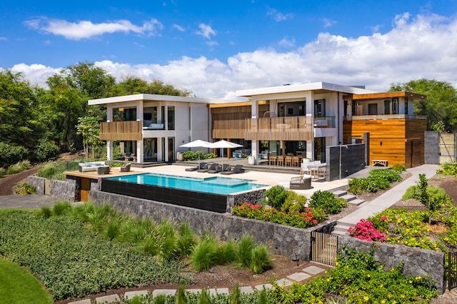 back of property with a balcony and a patio area